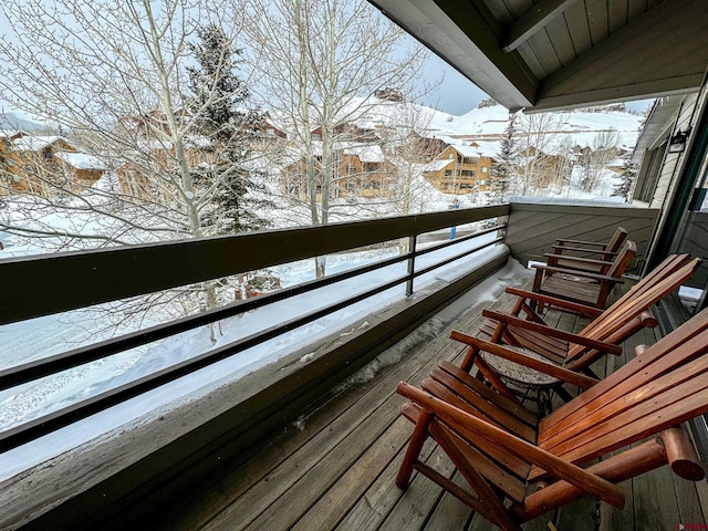 view of snow covered back of property