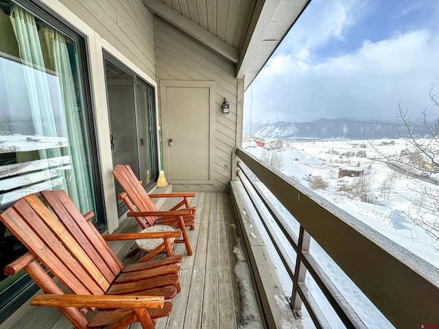 snow covered back of property with a mountain view