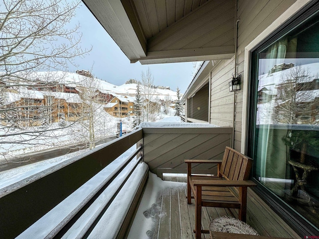 view of snow covered back of property