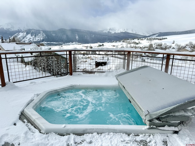 snow covered pool with fence and a mountain view