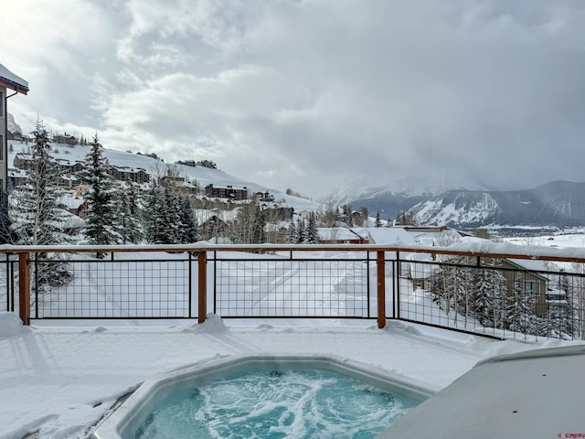 snow covered pool featuring fence and a mountain view