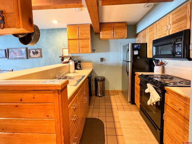 kitchen featuring light countertops, decorative backsplash, brown cabinetry, a sink, and black appliances