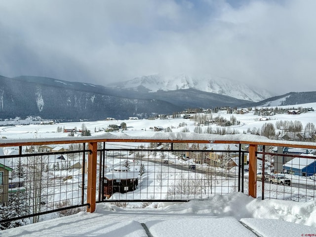 snow covered deck featuring a mountain view