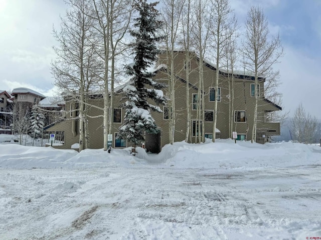 snow covered property with a garage