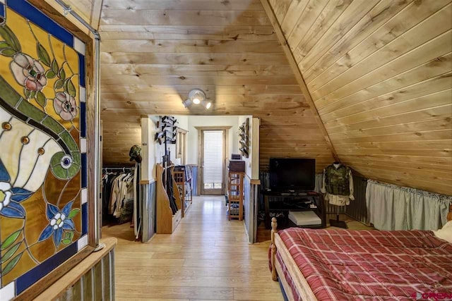 unfurnished bedroom featuring light wood-type flooring, wooden ceiling, wooden walls, and vaulted ceiling