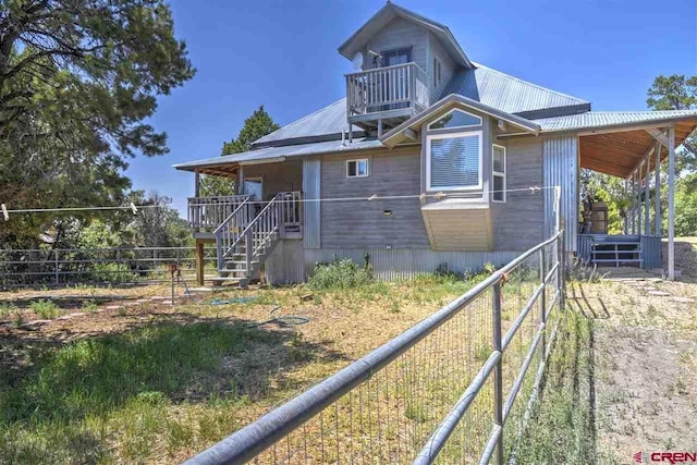 view of front of house with stairs and metal roof