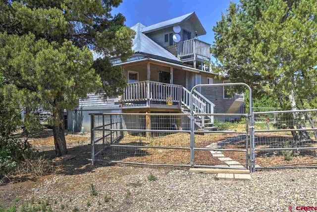 view of front facade with stairway, a gate, and fence