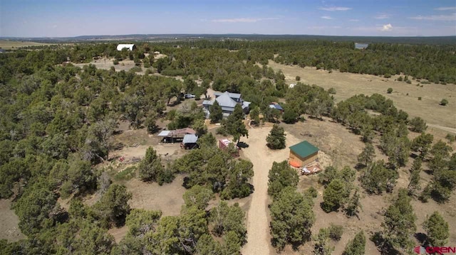 drone / aerial view with a wooded view