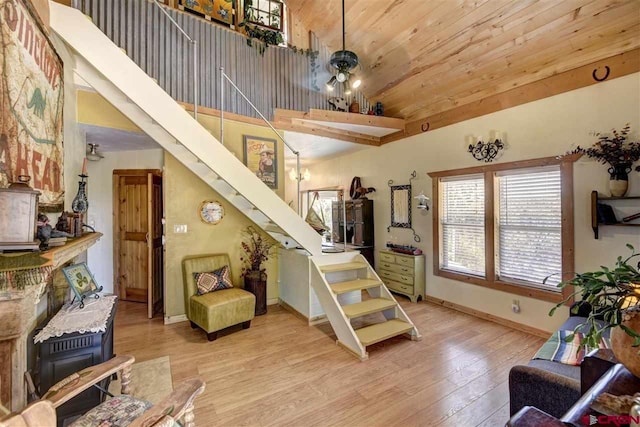 stairs featuring high vaulted ceiling, wooden ceiling, baseboards, and wood finished floors