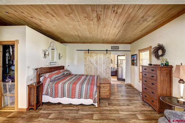 bedroom featuring wooden ceiling, a barn door, and wood finished floors