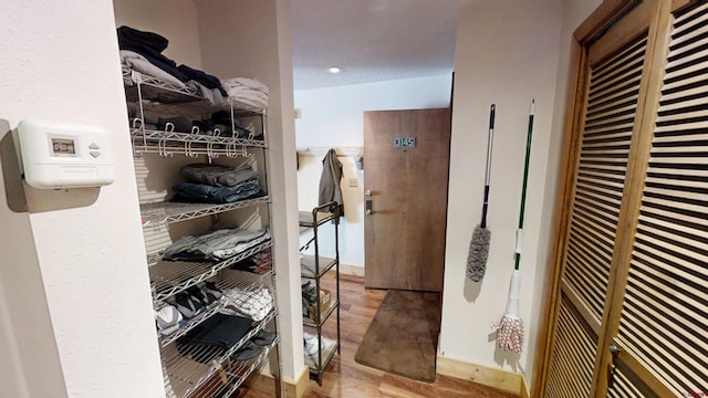 spacious closet featuring a heating unit and wood finished floors