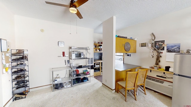 office space with baseboards, a ceiling fan, a textured ceiling, and light colored carpet