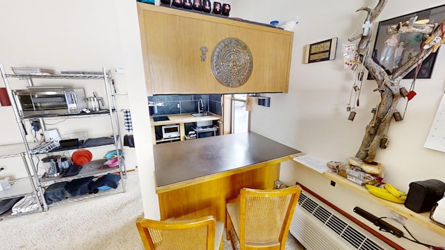 kitchen featuring carpet floors, light brown cabinets, and a toaster