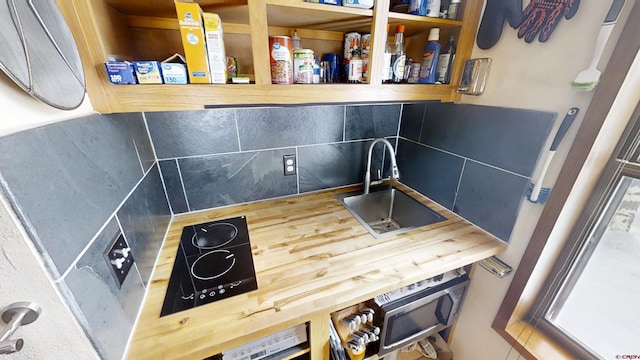 kitchen with tasteful backsplash, a sink, and stovetop