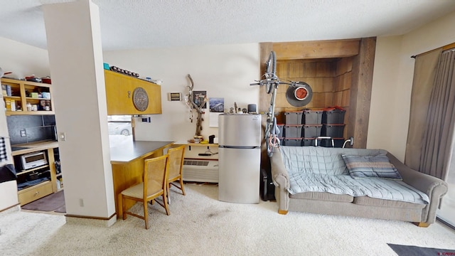 interior space featuring a textured ceiling, carpet floors, water heater, and freestanding refrigerator