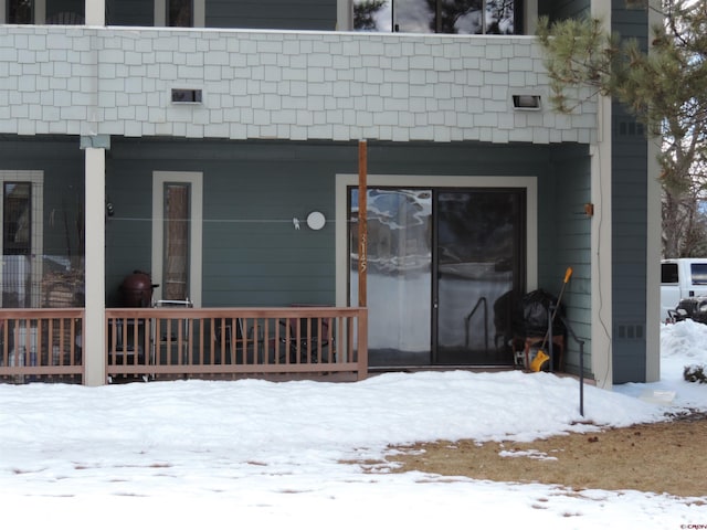 snow covered property entrance featuring covered porch