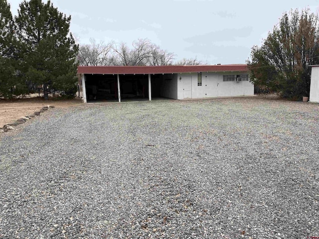 view of outbuilding with driveway and a carport