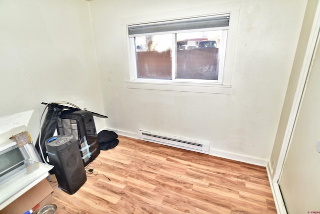 miscellaneous room with a baseboard radiator, light wood-style flooring, and baseboards