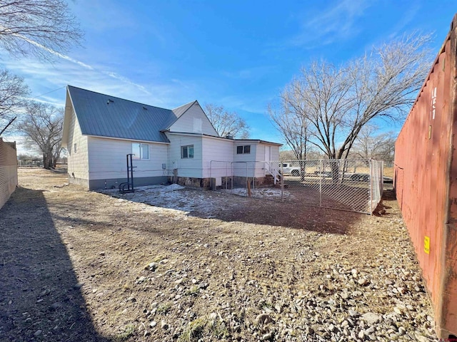 back of property with metal roof and fence