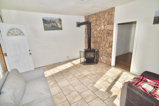 living area with a wood stove, baseboards, and light tile patterned flooring