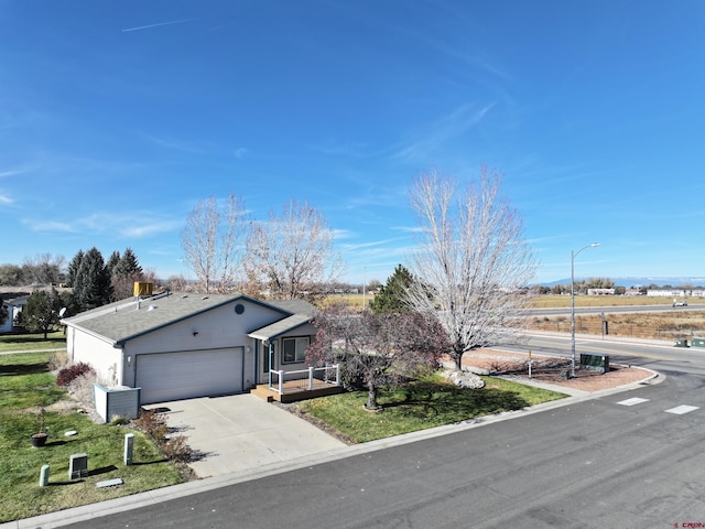 ranch-style home with a front yard, concrete driveway, and an attached garage