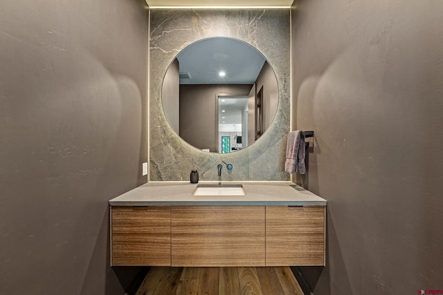 bathroom with tasteful backsplash, wood finished floors, and vanity