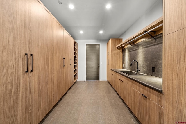 kitchen featuring a sink, open shelves, tasteful backsplash, dark countertops, and modern cabinets