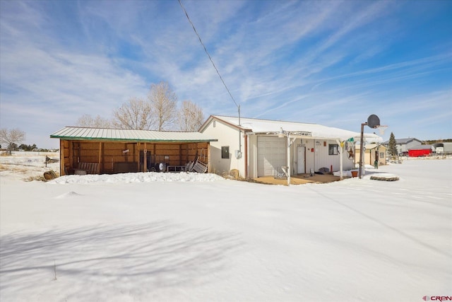 snow covered property with metal roof