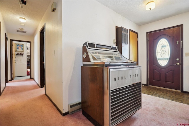 foyer featuring a textured ceiling, visible vents, and carpet flooring