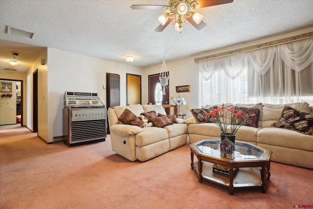 living area featuring carpet floors, ceiling fan, visible vents, and a textured ceiling