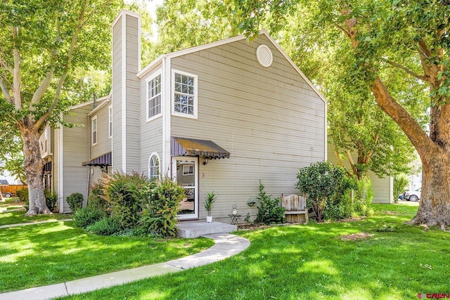 view of front of home with a front lawn and a chimney