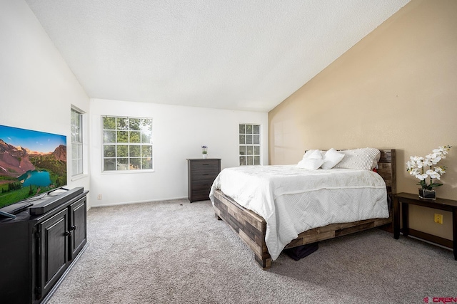 carpeted bedroom with vaulted ceiling and a textured ceiling