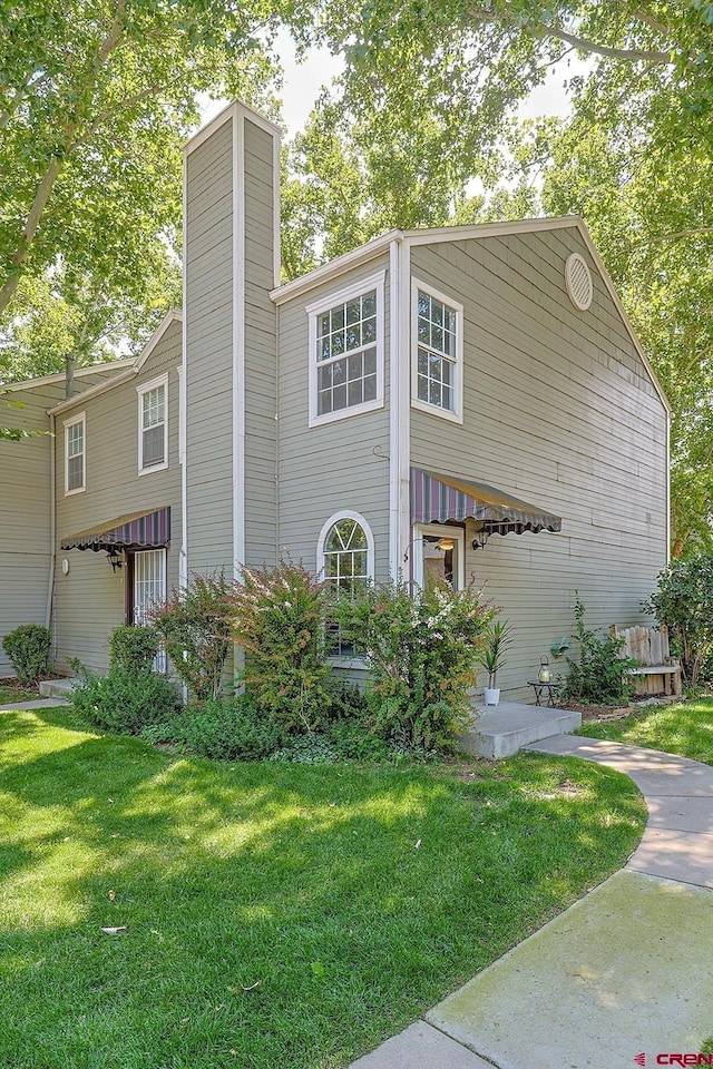 view of front facade featuring a front yard and a chimney