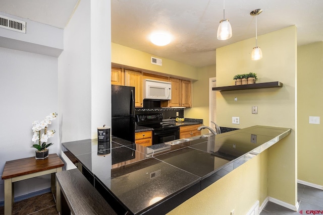 kitchen featuring tile countertops, black appliances, visible vents, and a sink