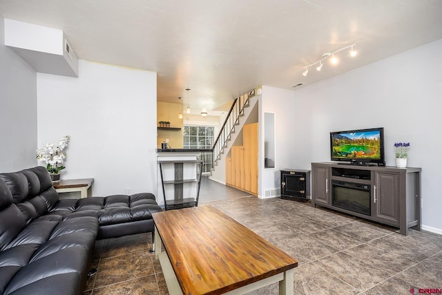 living room featuring stairs and baseboards