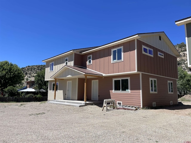 back of property featuring crawl space and board and batten siding