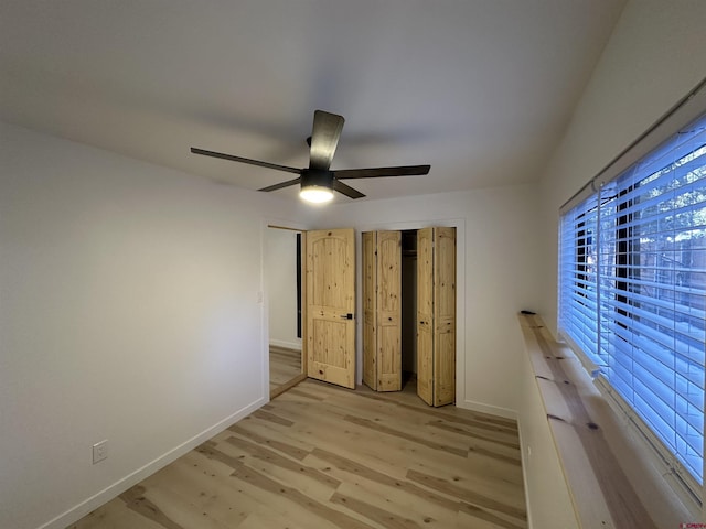 unfurnished bedroom with a ceiling fan, a closet, baseboards, and light wood finished floors