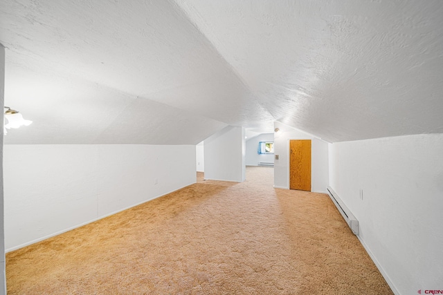 bonus room with carpet floors, baseboard heating, vaulted ceiling, a textured ceiling, and baseboards