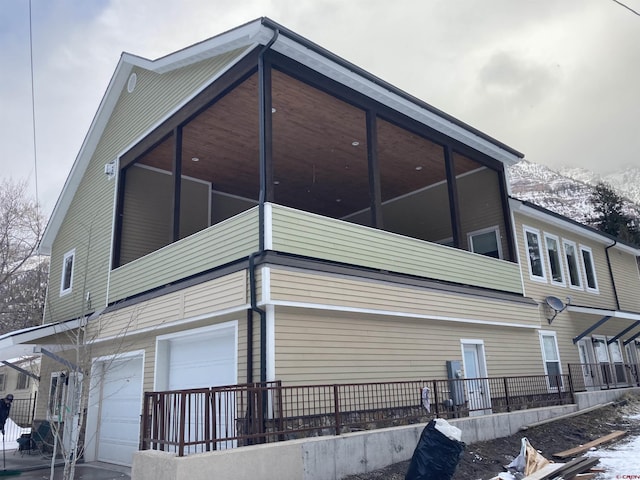 view of snow covered exterior featuring an attached garage