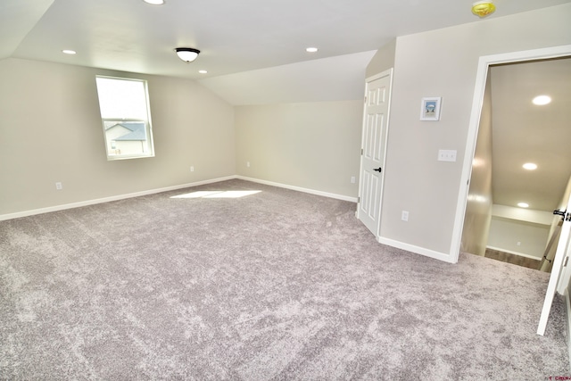 carpeted spare room featuring lofted ceiling, baseboards, and recessed lighting