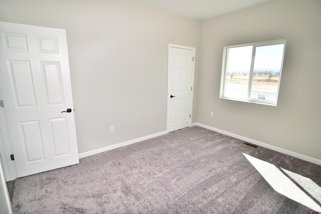 unfurnished bedroom with light carpet, baseboards, and visible vents