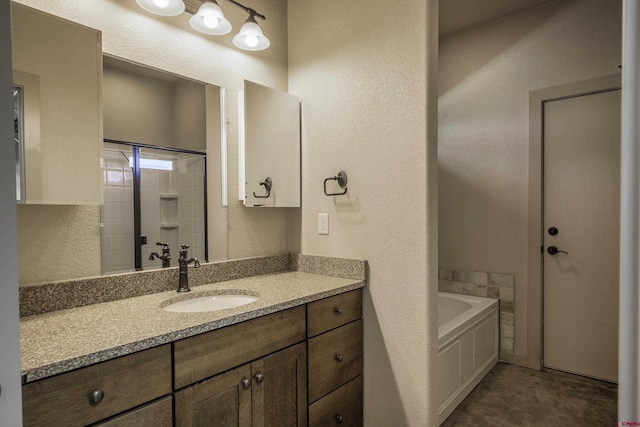 full bathroom with a textured wall, vanity, and a tub