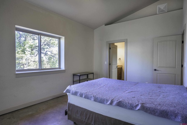 bedroom featuring lofted ceiling, visible vents, and connected bathroom