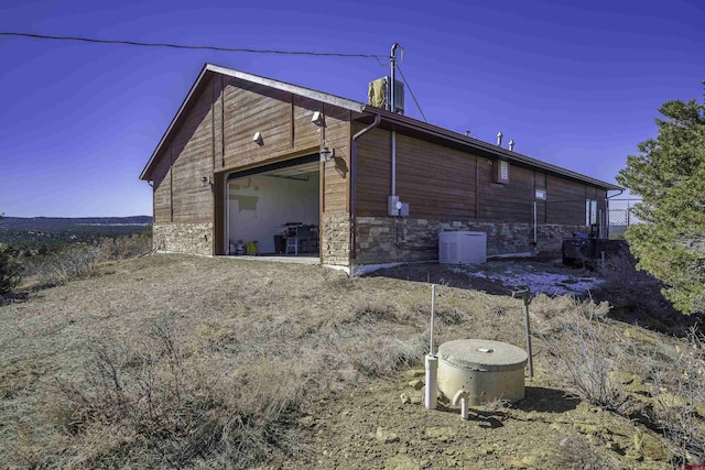 view of property exterior with a garage and stone siding