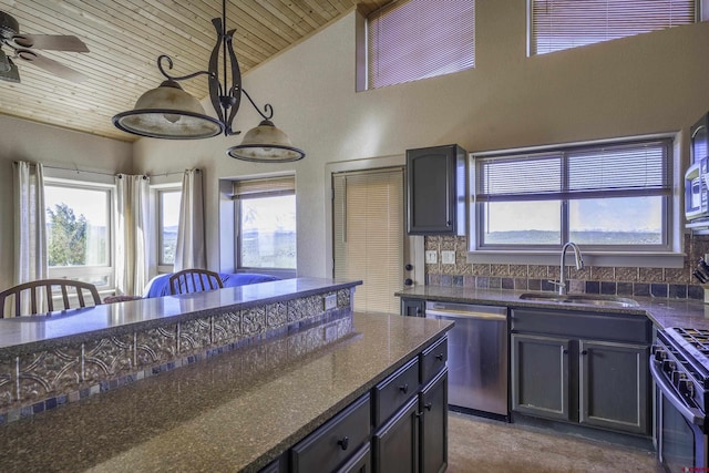 kitchen featuring decorative light fixtures, stainless steel appliances, a sink, dark stone counters, and wooden ceiling