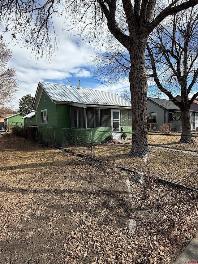 exterior space featuring a fenced front yard and metal roof