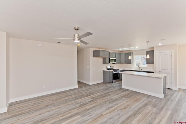 670 Nuvue St Cyprus Floorplan, Cyprus Floorplan, Delta, CO 81416 - kitchen featuring stainless steel appliances, gray cabinetry, light wood-style flooring, light countertops, and a center island