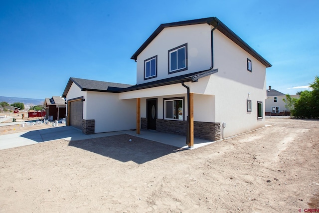 670 Nuvue St Cyprus Floorplan, Cyprus Floorplan, Delta, CO 81416 - rear view of property with stone siding, stucco siding, a garage, and concrete driveway