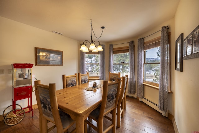 dining space featuring a baseboard heating unit, plenty of natural light, dark wood-style floors, and a chandelier