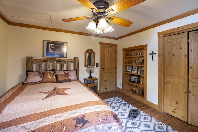 bedroom featuring baseboards, wood finished floors, attic access, and crown molding